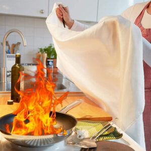 Fire blanket smothering a stove fire